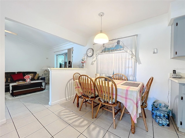 tiled dining room featuring a healthy amount of sunlight and ornamental molding