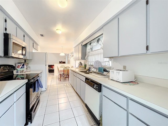 kitchen with pendant lighting, light tile patterned flooring, white appliances, and sink