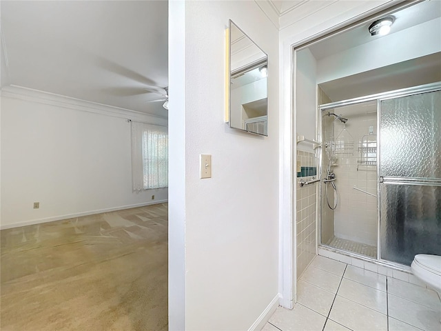 bathroom with tile patterned floors, a shower with door, ornamental molding, and ceiling fan