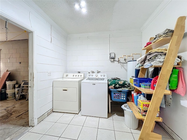 laundry room with water heater, a textured ceiling, light tile patterned floors, washer and dryer, and ornamental molding