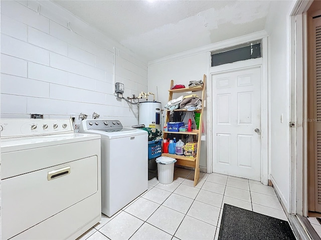 clothes washing area with electric water heater, light tile patterned floors, and washer and dryer