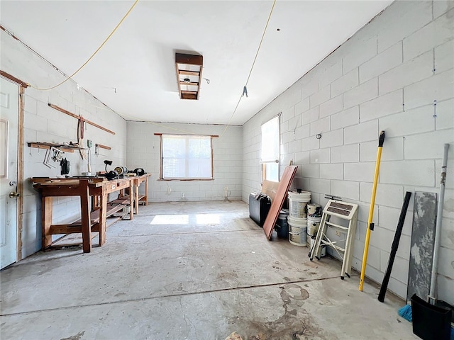 misc room with a workshop area and concrete floors