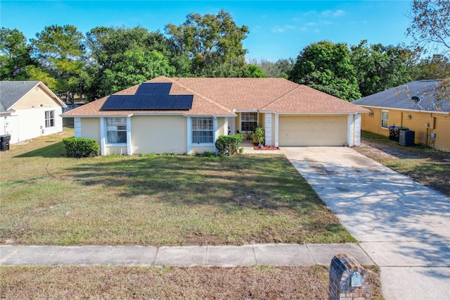 single story home with central AC, a front lawn, a garage, and solar panels