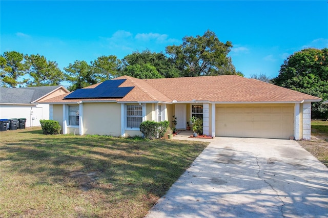 ranch-style home with solar panels, a garage, and a front lawn