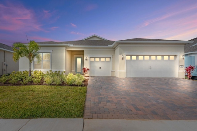 view of front of home with a garage and a lawn