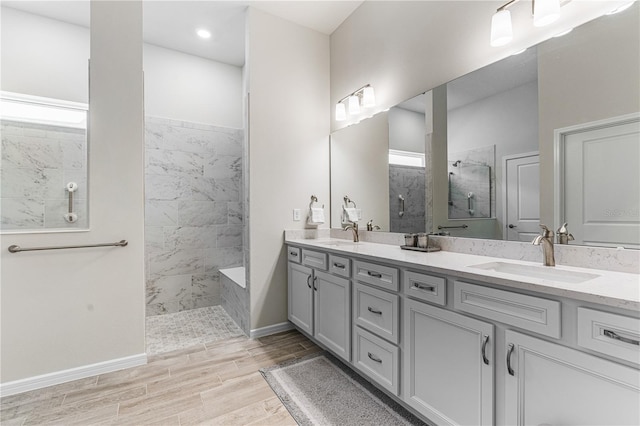 bathroom featuring tiled shower and vanity