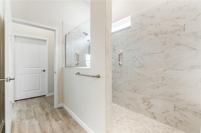 bathroom featuring hardwood / wood-style flooring and a tile shower