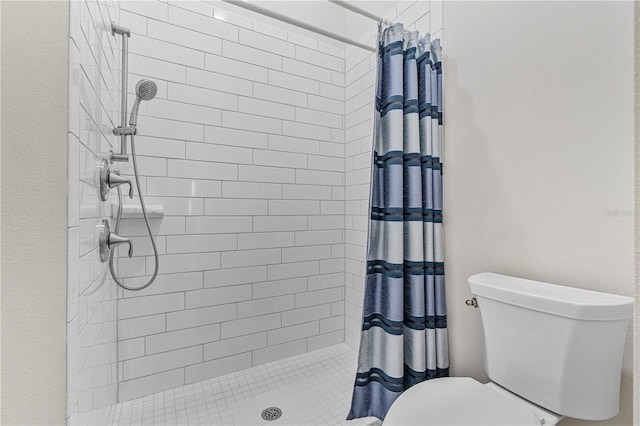 bathroom featuring a shower with curtain and toilet