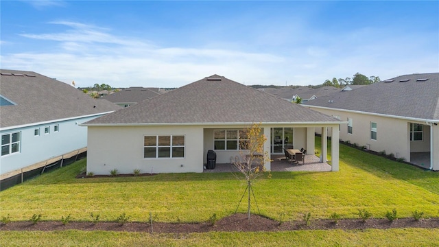 back of property with a yard and a patio