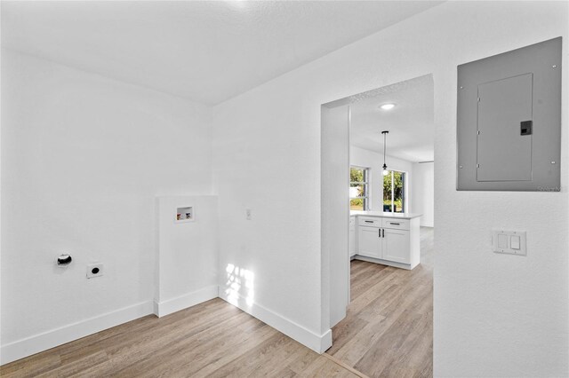 clothes washing area with washer hookup, electric panel, electric dryer hookup, and light hardwood / wood-style floors