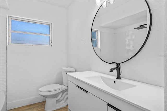 bathroom with hardwood / wood-style flooring, vanity, toilet, and a shower