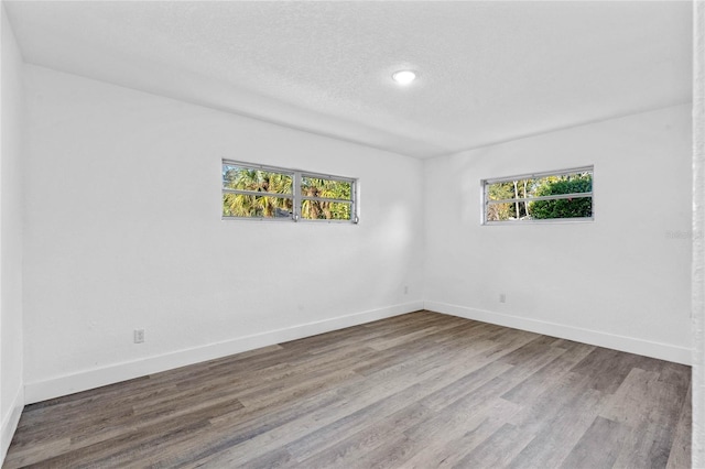 empty room featuring a textured ceiling and hardwood / wood-style flooring