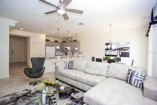 living room with ceiling fan with notable chandelier