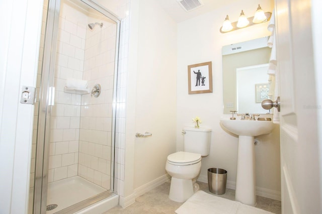 bathroom featuring toilet and a shower with door