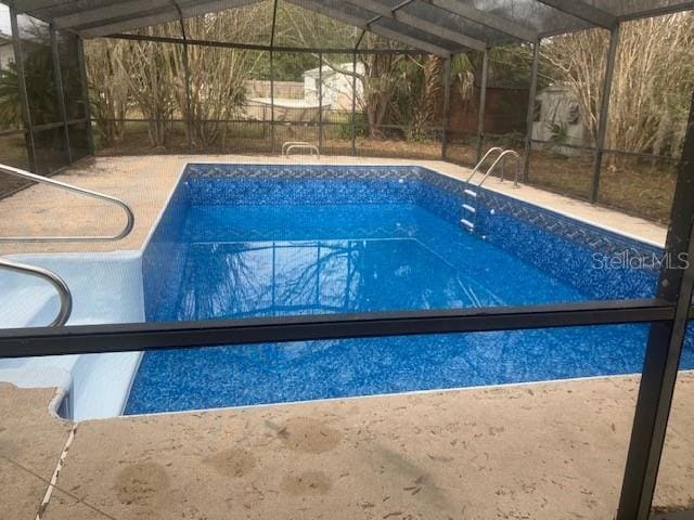 view of swimming pool featuring a lanai