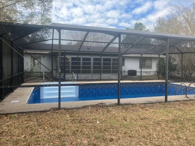 view of swimming pool featuring a lanai