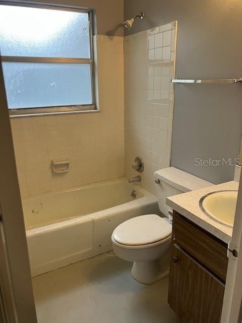 full bathroom featuring tiled shower / bath combo, toilet, and vanity