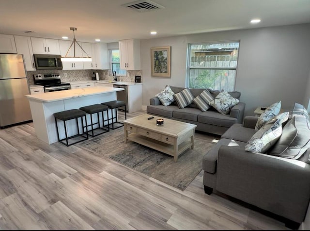 living room with sink and light hardwood / wood-style flooring