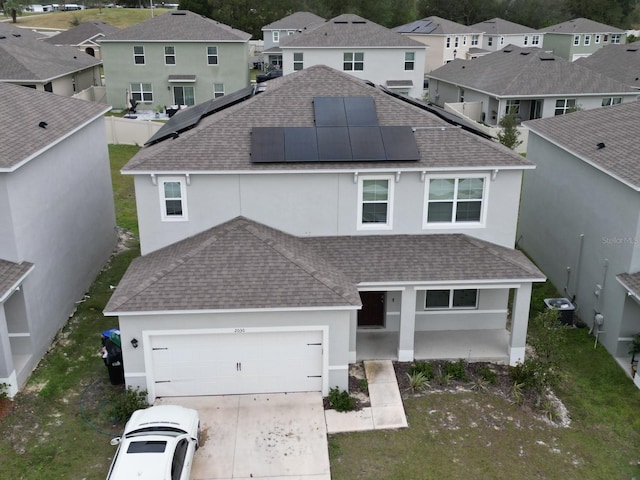 view of front facade with central AC, a garage, and solar panels