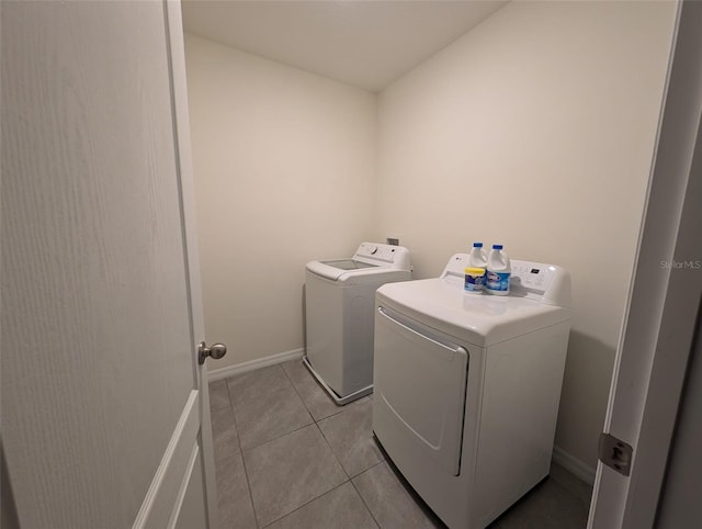 clothes washing area with washer and clothes dryer and light tile patterned floors