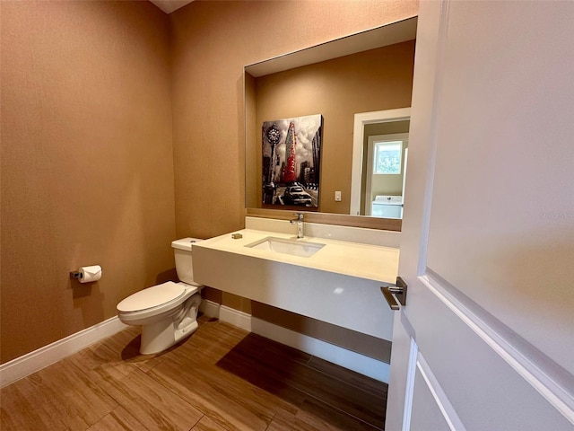 bathroom with hardwood / wood-style flooring, toilet, and sink