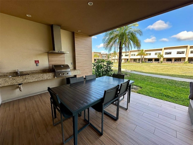 wooden deck with a yard, a grill, and sink