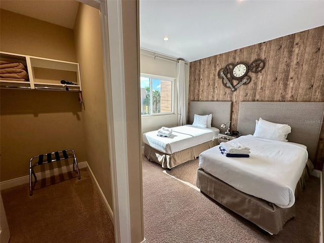 bedroom with carpet flooring and wood walls