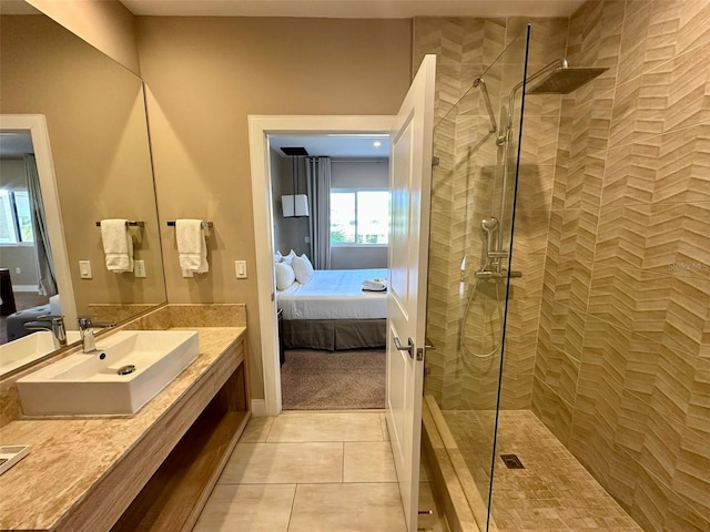 bathroom featuring a tile shower, tile patterned flooring, and vanity