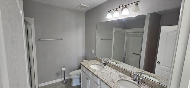 bathroom with tile patterned floors, vanity, a textured ceiling, toilet, and a shower with shower door