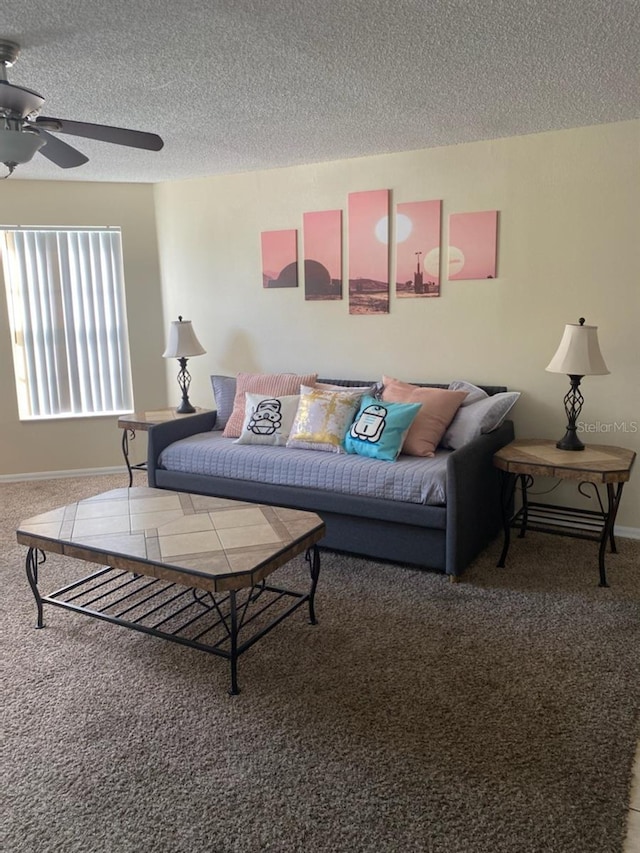 living room featuring ceiling fan, carpet floors, and a textured ceiling