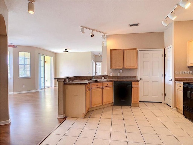 kitchen featuring dishwasher, stove, sink, light tile patterned floors, and kitchen peninsula