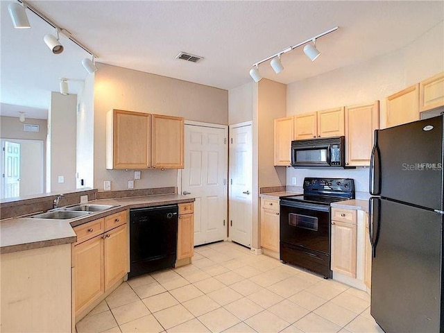 kitchen with light tile patterned flooring, light brown cabinetry, sink, and black appliances