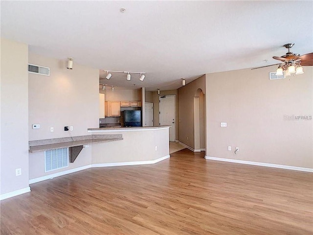 unfurnished living room featuring ceiling fan and light hardwood / wood-style floors