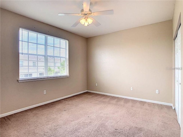 carpeted empty room featuring ceiling fan