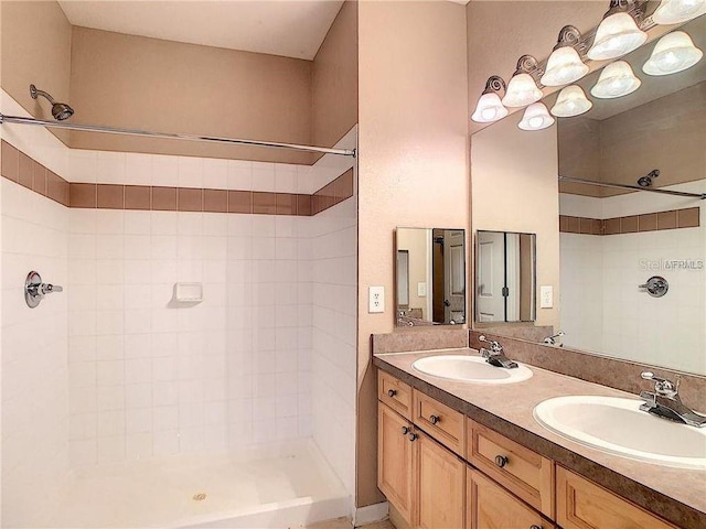 bathroom with tiled shower and vanity