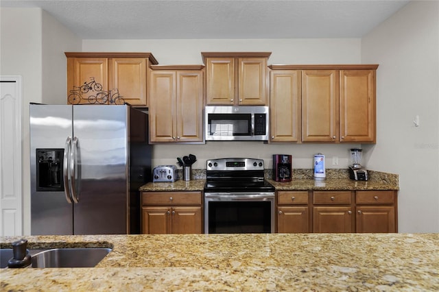 kitchen with light stone counters and stainless steel appliances