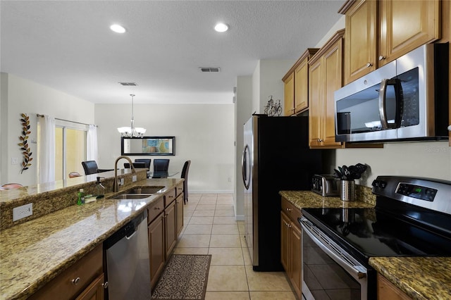 kitchen featuring light tile patterned flooring, sink, a notable chandelier, light stone counters, and stainless steel appliances