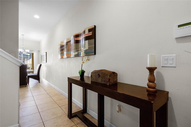 hallway featuring a chandelier and light tile patterned floors