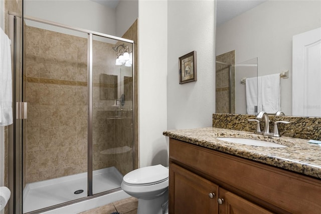 bathroom with toilet, vanity, tile patterned floors, and a shower with door