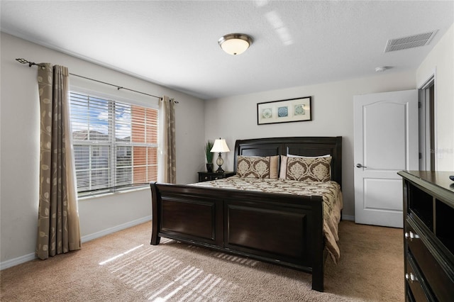 bedroom with light carpet and a textured ceiling