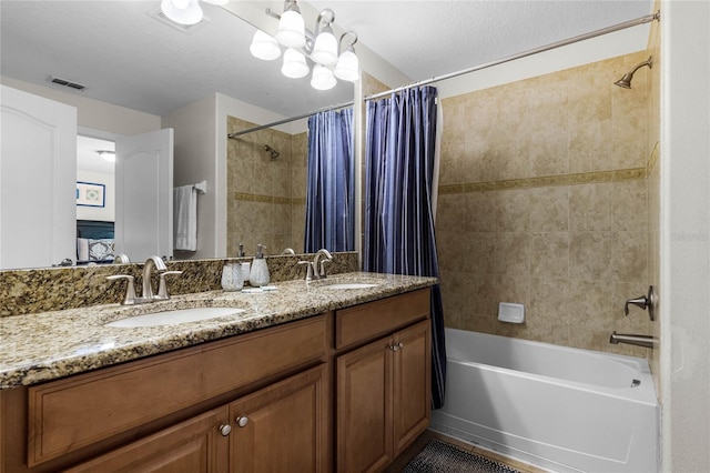 bathroom with vanity, a textured ceiling, an inviting chandelier, and shower / bath combo with shower curtain