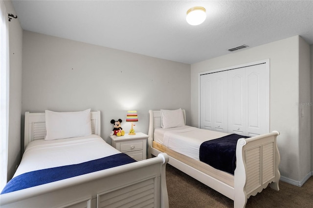 bedroom with carpet floors, a closet, and a textured ceiling