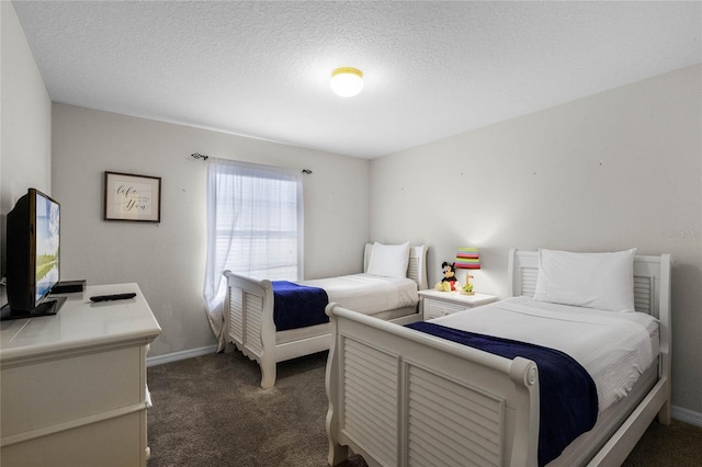 bedroom featuring dark carpet and a textured ceiling