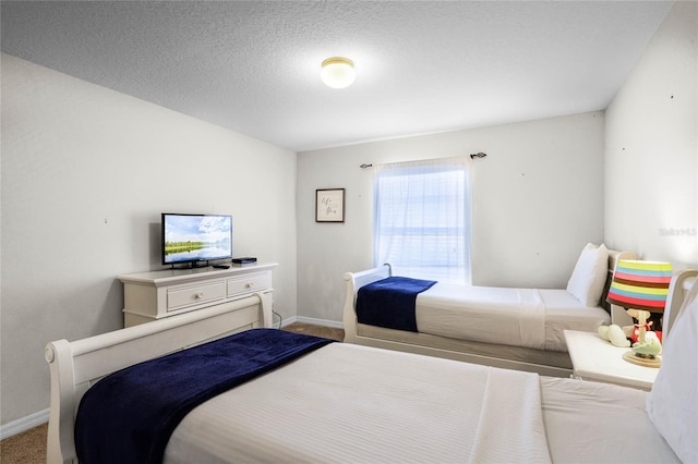 bedroom with a textured ceiling and light colored carpet