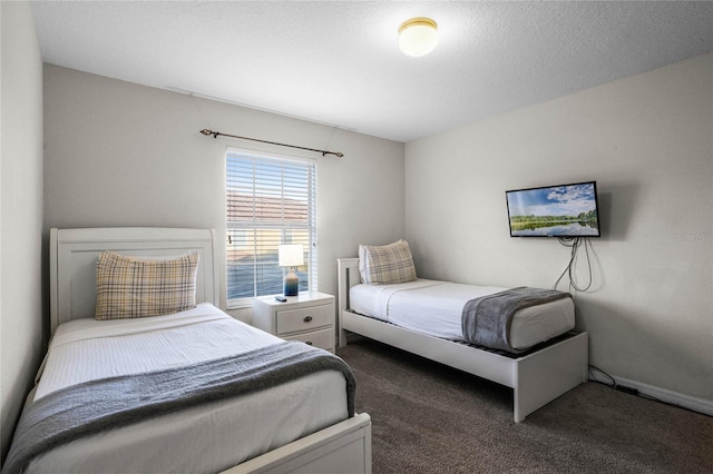 bedroom with a textured ceiling and dark colored carpet