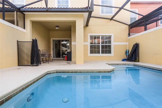 view of swimming pool featuring a patio area and glass enclosure