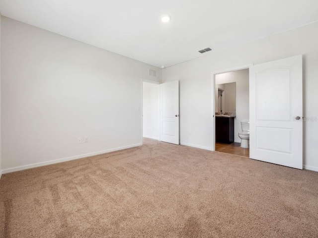 unfurnished bedroom featuring carpet flooring and ensuite bath