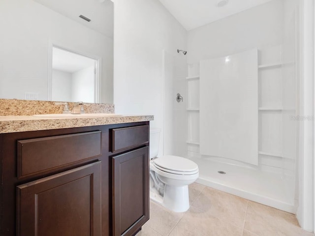 bathroom featuring a shower, tile patterned flooring, vanity, and toilet