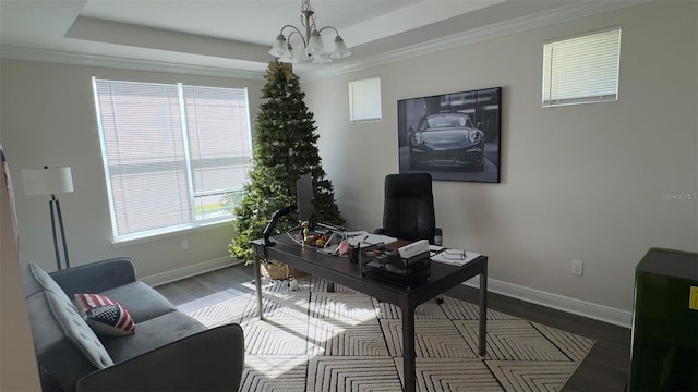 office featuring hardwood / wood-style floors, a raised ceiling, ornamental molding, and an inviting chandelier