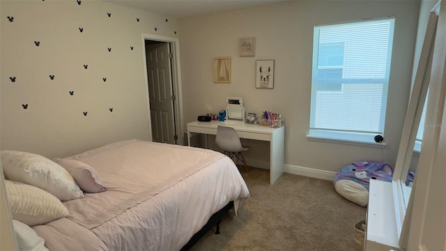 bedroom featuring light carpet and multiple windows